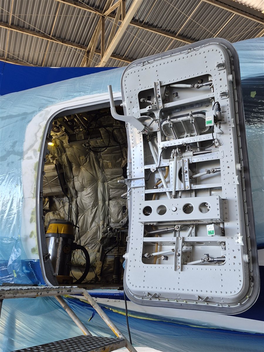 Painel de acesso aberto mostrando componentes internos da aeronave